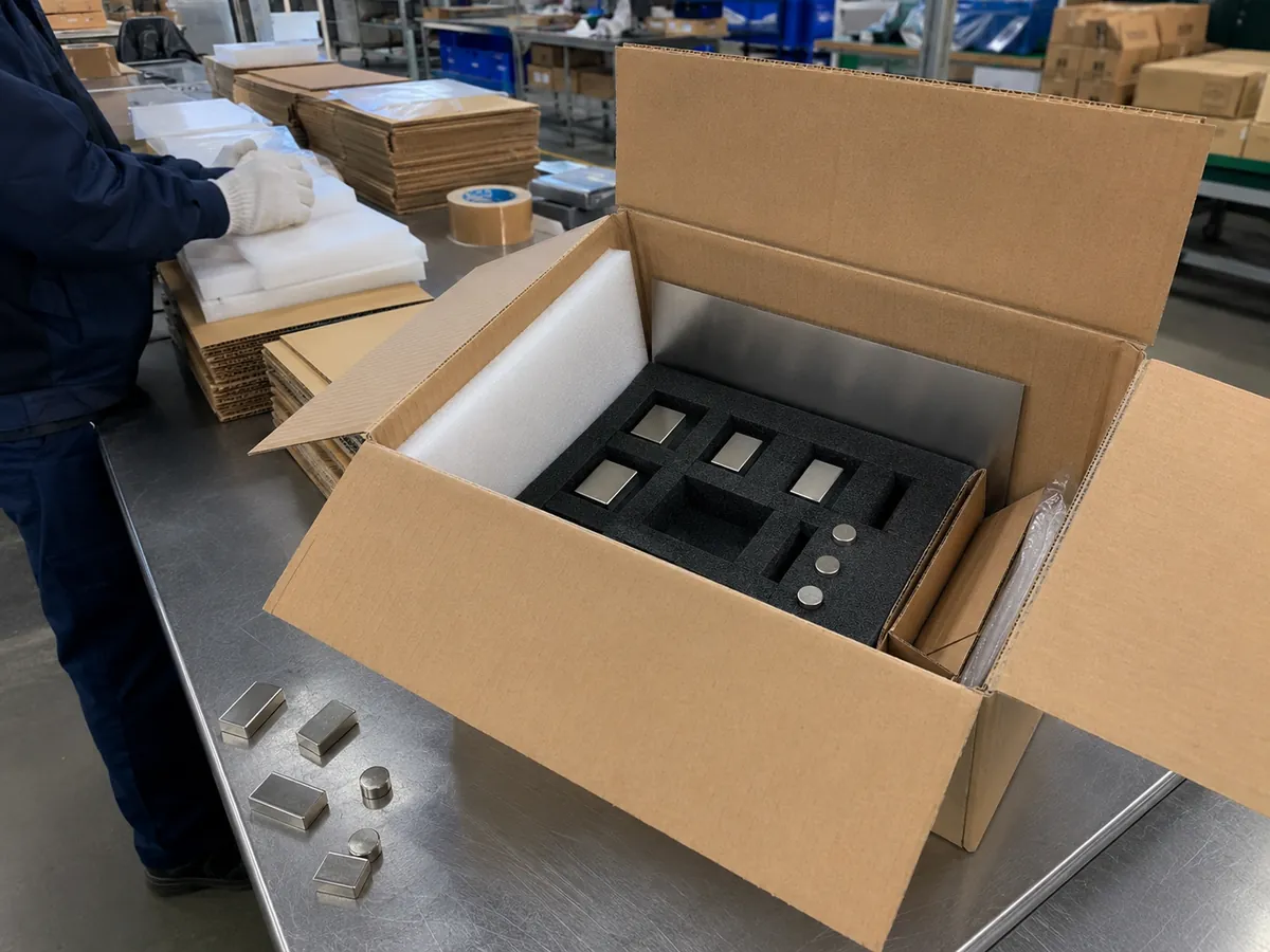 Für den Versand in Schaumstoff verpackte Neodym-Magnete an einer Werkbank in der OSENC-Fabrik